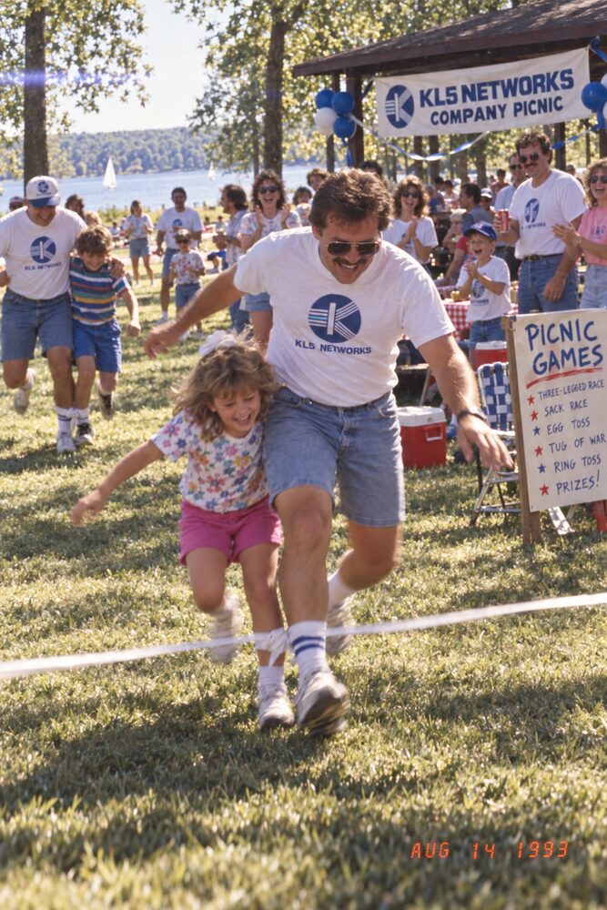 A parent and child running in a picnic game